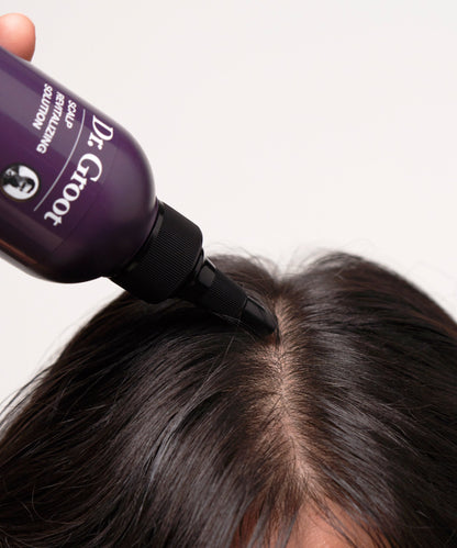 Model using the Scalp Revitalizing Solution Miracle in Shower Treatment for thicker, healthier hair.